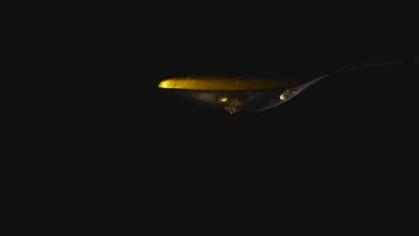 Μέλι που ρέει από το κουτάλι μαύρο φόντο - Πλάνα, βίντεο