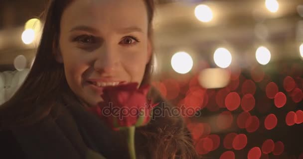 Gorgeous brunette girl in standing with red rose in a city. - Кадри, відео
