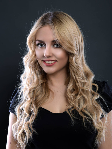 Blonde girl with long and volume shiny wavy hair . Beautiful woman model with curly hairstyle . - Photo, Image
