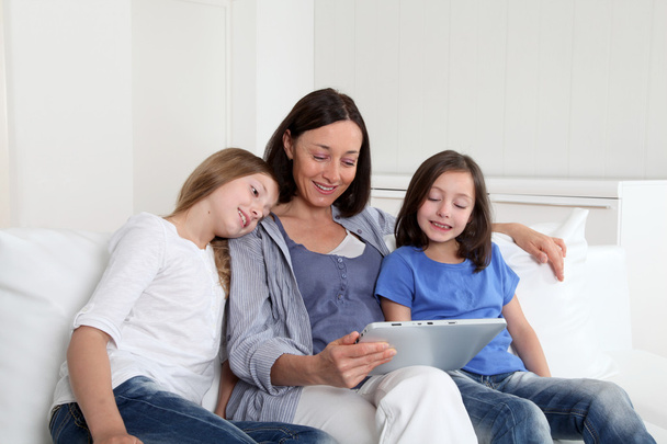 Madre e ragazze che utilizzano tablet elettronico a casa
 - Foto, immagini
