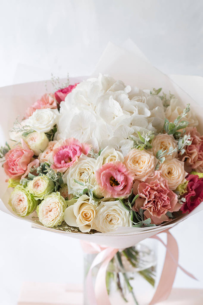 virág kompozíció, rózsák és a mix virágok üveg váza, egy szürke háttér. - Fotó, kép