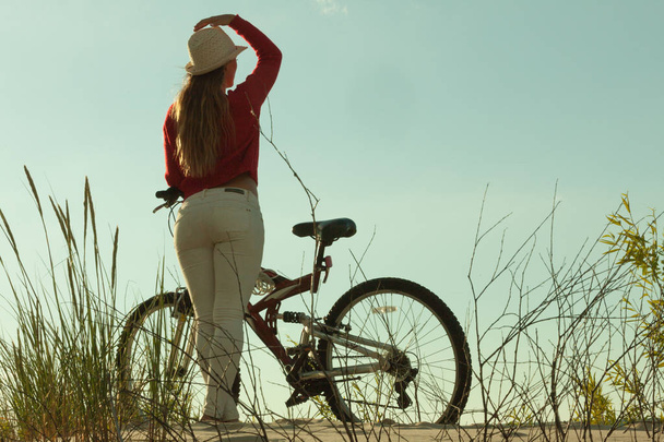 Unrecognizable woman bike cycling on sand - Foto, Imagen
