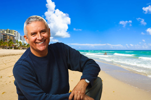 Красивый портрет мужчины среднего возраста на открытом воздухе с пляжным фоном
. - Фото, изображение