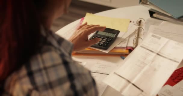 Donna anziana utilizzando calcolatrice per le tasse e il bilancio a casa
 - Filmati, video