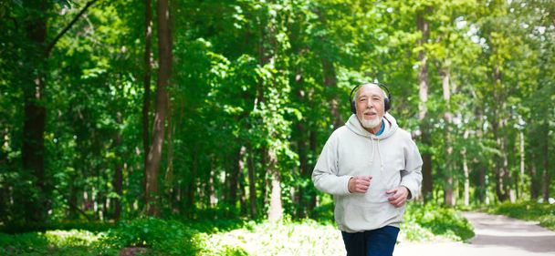 Homem idoso correndo na floresta verde, espaço de cópia
 - Foto, Imagem