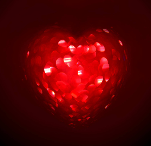 Red Blur heart shape of ligth bokeh on a black background. - Фото, зображення