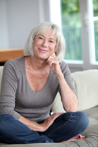 Portrait of smiling senior woman sitting in sofa - Foto, imagen