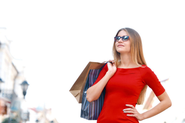 Portrait young charming long-haired woman holding shopping bags. Shopping sales and perfect mood. Design model fashion glasses. - Photo, Image