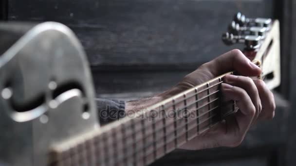 Detailní zobrazení Perspektiva kavkazské mladý muž ruky hraje na akustickou kytaru kovové Dobson na tmavém pozadí - Záběry, video