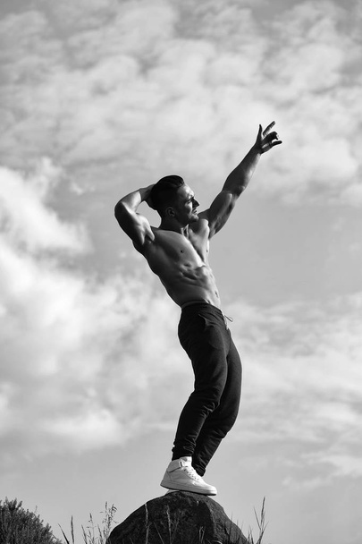Sexy muscular man on sky background - 写真・画像