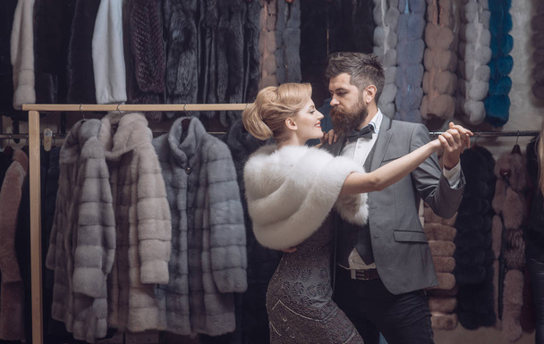 Man and woman with coats in fur shop. - Fotoğraf, Görsel