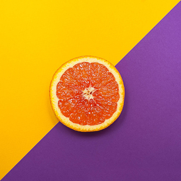 Minimal style, creative layout orange and grapefruit. Flat lay. Food concept. Half an orange on yellow purple background. - Zdjęcie, obraz