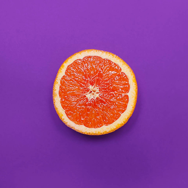 Minimal style, creative layout orange and grapefruit. Flat lay. Food concept. Half an orange on purple background. - Valokuva, kuva