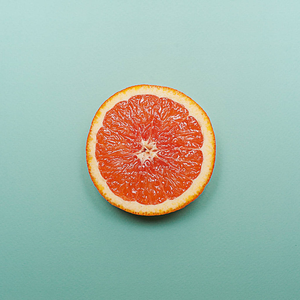 Minimal style, creative layout orange and grapefruit. Flat lay. Food concept. Half an orange on turquoise background. - Fotografie, Obrázek