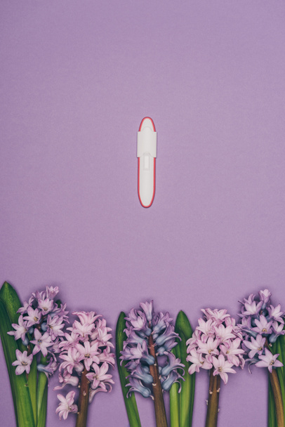 top view of arranged flowers and pregnancy test isolated on purple  - Photo, Image