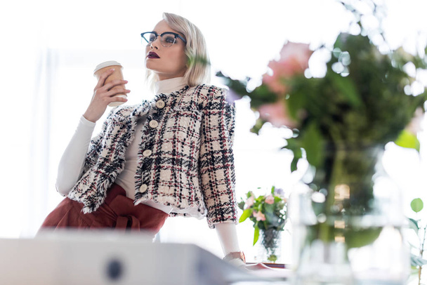 attractive fashionable businesswoman with coffee to go in modern office - Photo, Image