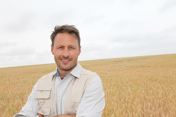 Portrait of handsome man standing in wheat field - Fotoğraf, Görsel