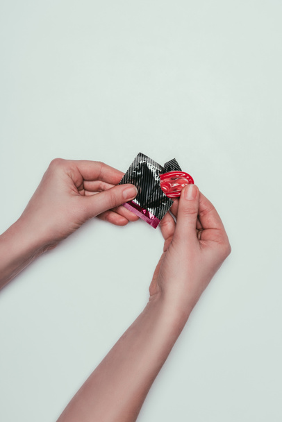částečný pohled žena otevírání kondom izolované Grey - Fotografie, Obrázek