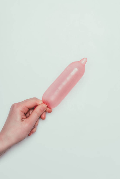 gri izole elinde tutan kadın açılan kısmi görünümünü prezervatif - Fotoğraf, Görsel