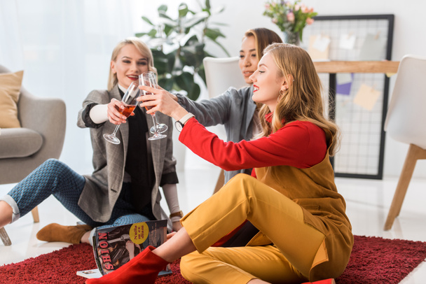 successful fashionable businesswomen celebrating and clinking with champagne glasses in office  - Zdjęcie, obraz