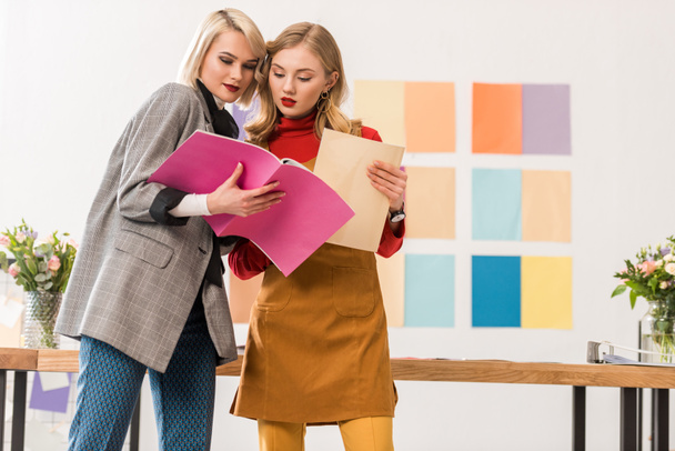 editores de revistas de moda que trabajan con documentos en la oficina moderna con paleta de colores en la pared
 - Foto, imagen