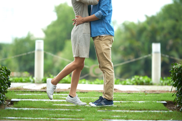 Porträt eines liebevollen jungen Paares, das sich bei einem Date im Park umarmt - Foto, Bild