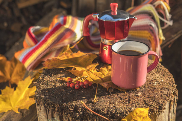Lenço multicolorido, xícara de café, cafeteira vermelha, mapl amarelo
 - Foto, Imagem