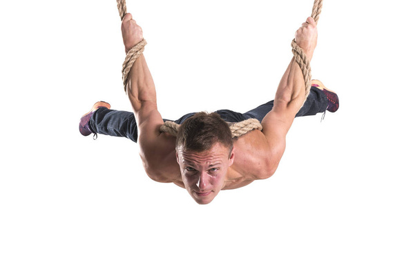 The man hanging on the ropes with a strained expression on his face isolated on white background - Foto, imagen