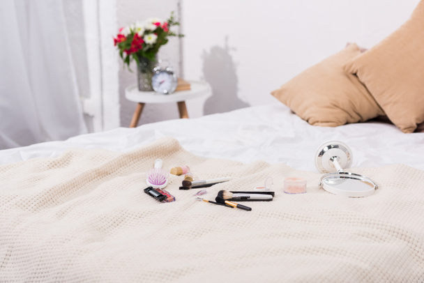 close-up shot of makeup supplies lying on bed - Photo, Image