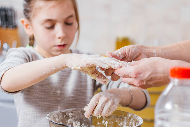 Mother and daughter making dough at home kitchen - 写真・画像