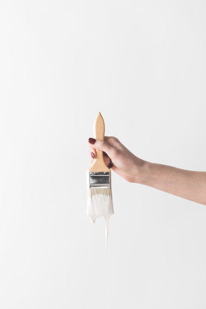 cropped image of woman holding brush in white paint isolated on white - Photo, image