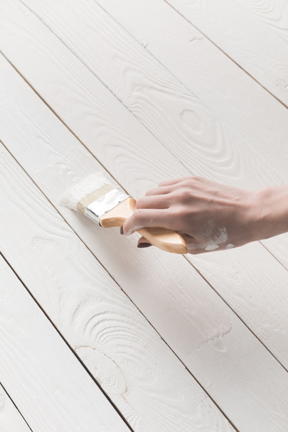 cropped image of woman painting wooden surface with white paint - Photo, image