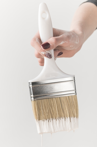 cropped image of girl holding brush in white paint isolated on white - Foto, Imagen