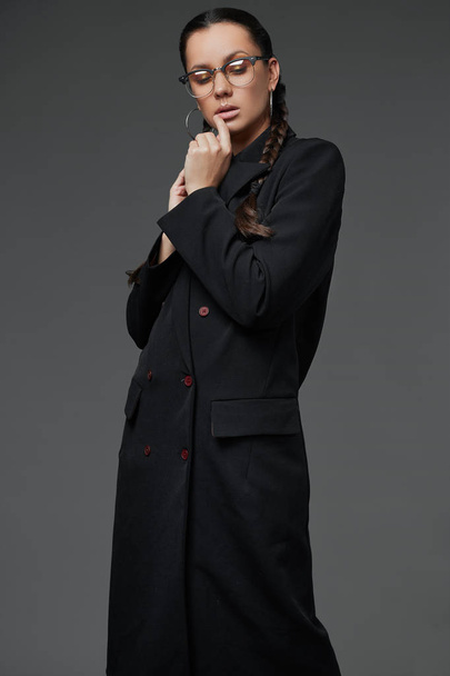 Gyönyörű bájos hispán lány hosszú fekete kabát portréja - Fotó, kép