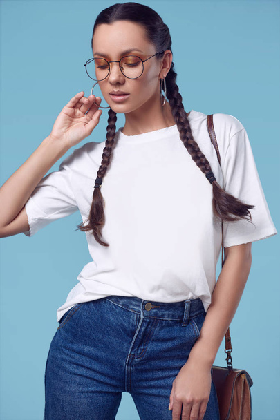 Beautiful charming hispanic girl in white t-shirt, jeans and glasses - Fotó, kép