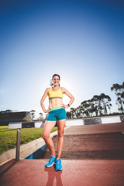 Female fitness model and track athlete  on an athletics track made from tartan - Φωτογραφία, εικόνα