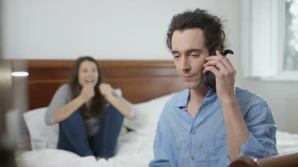 4K Happy couple in the bedroom at home get good news from a phone call - Materiał filmowy, wideo