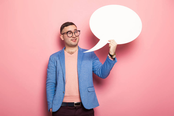 Handsome young man with blank paper speech bubble against pink background  - Fotoğraf, Görsel