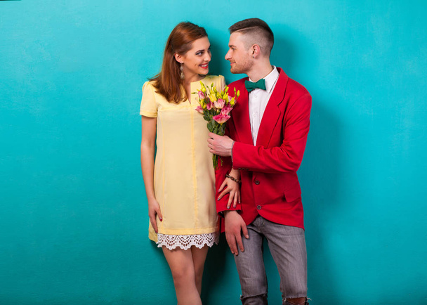 hipster couple in love with a bouquet of flowers in the studio at Christmas, the concept of Valentine's Day - Fotó, kép