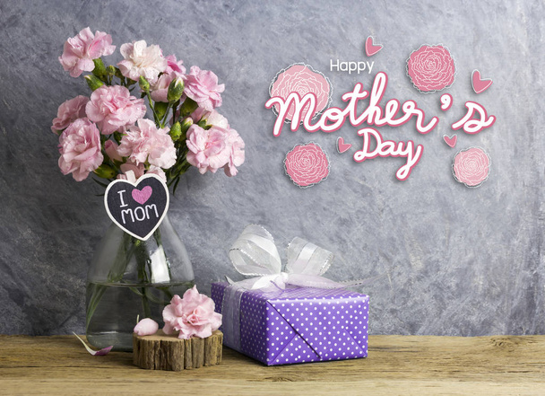 Feliz madre día concepto de flores de clavel rosa en botella con i love mamá carta en madera corazón y violeta caja de regalo
 - Foto, imagen