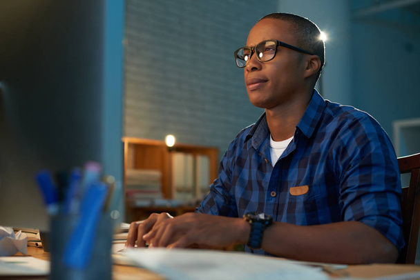 Низький кут зору юнак темношкірі сидять на столі в офісі - Фото, зображення