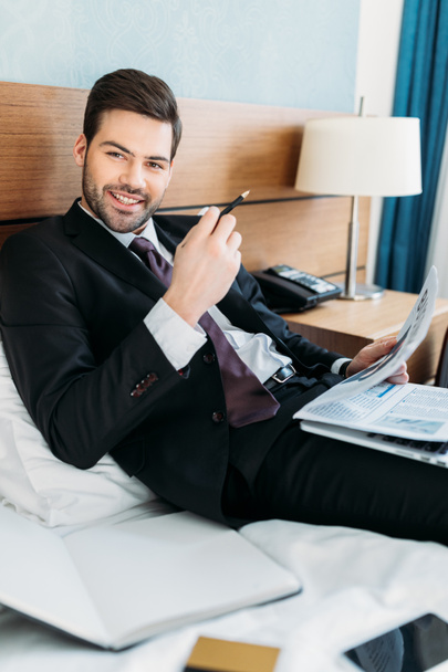 happy businessman holding newspaper and looking at camera - Photo, Image