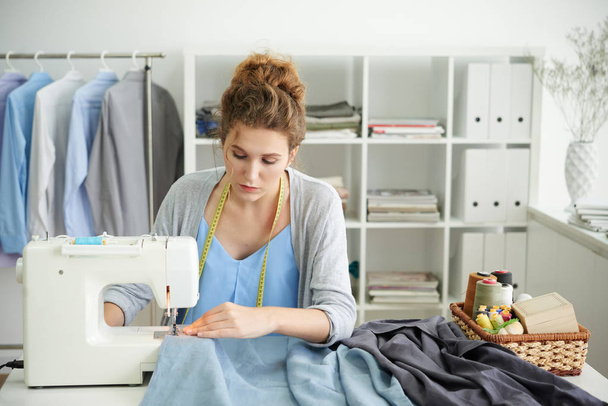 Απασχολημένος με ράβοντας πουκάμισα στο ατελιέ της γυναικείας ράφτης - Φωτογραφία, εικόνα