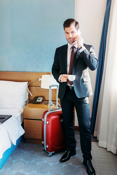 bel homme d'affaires parlant par smartphone dans la chambre d'hôtel
 - Photo, image