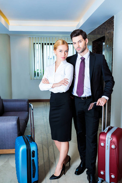 homem de negócios e mulher de negócios com passaportes e bilhetes no corredor do hotel
 - Foto, Imagem