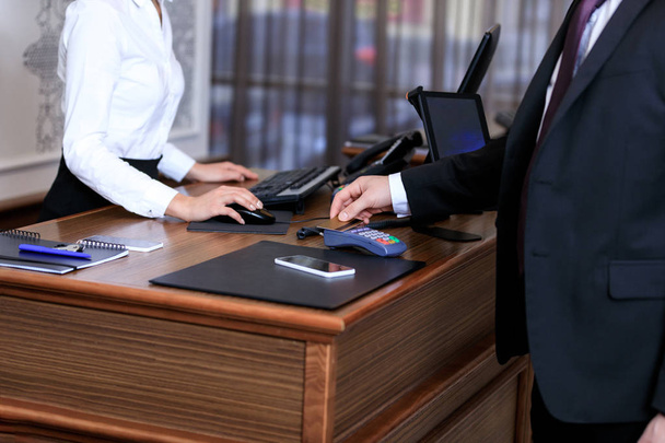 обрезанный образ бизнесмена, платящего кредитной картой в отеле
 - Фото, изображение