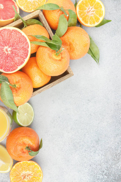 Fresh citruses. Mandarin, grapefruit, lime, tangerine, lemon and juice on stone background.  - Фото, зображення