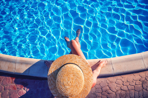 nő a medence mellett pihentető szalmakalap - Fotó, kép
