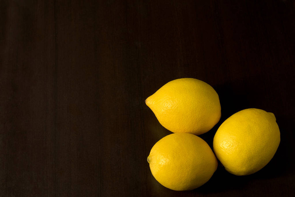 Group of three lemons - view from above on dark background - Zdjęcie, obraz