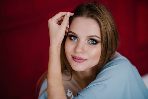 Beautiful young woman with make up  in blue dress posing in studio - Fotografie, Obrázek